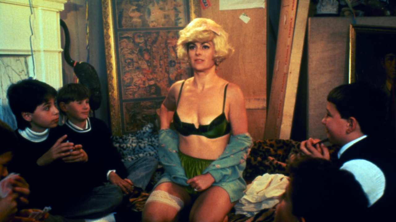 a blonde woman sitting with a group of children